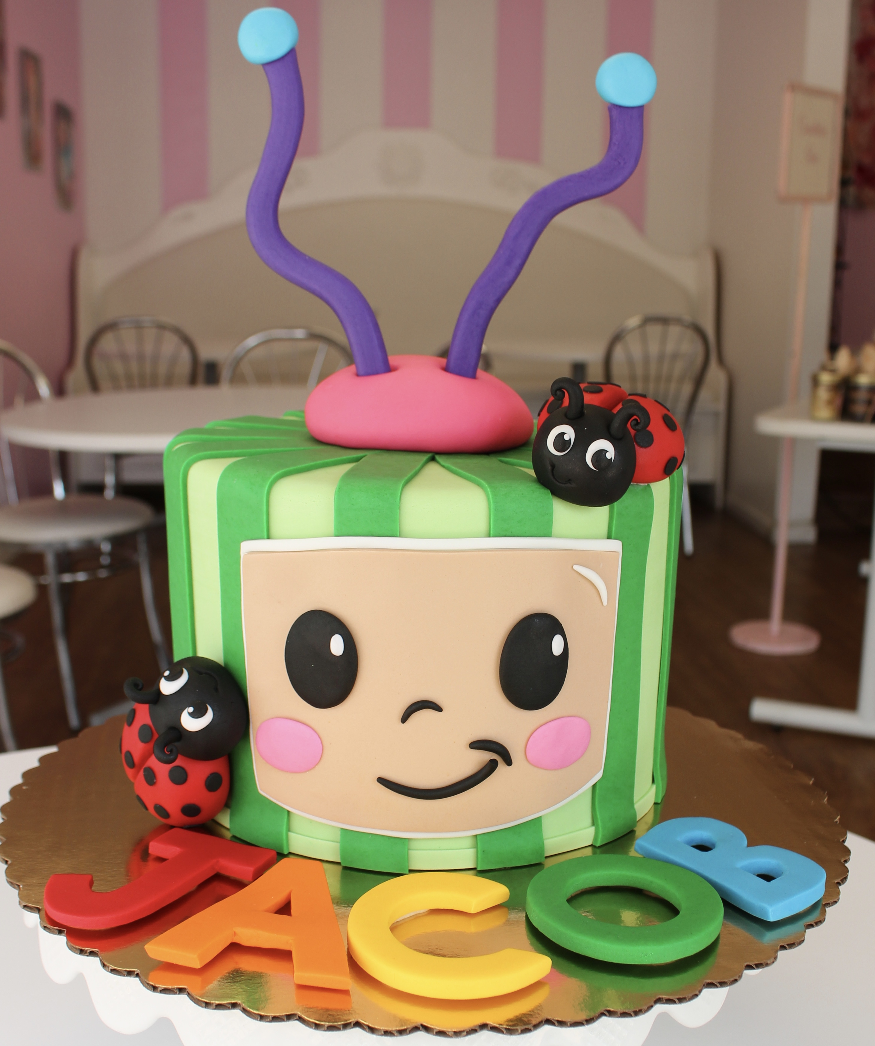 CocoMelon Themed Kids Birthday Cake with Fondant Lady Bugs and InsRainbow Lettering