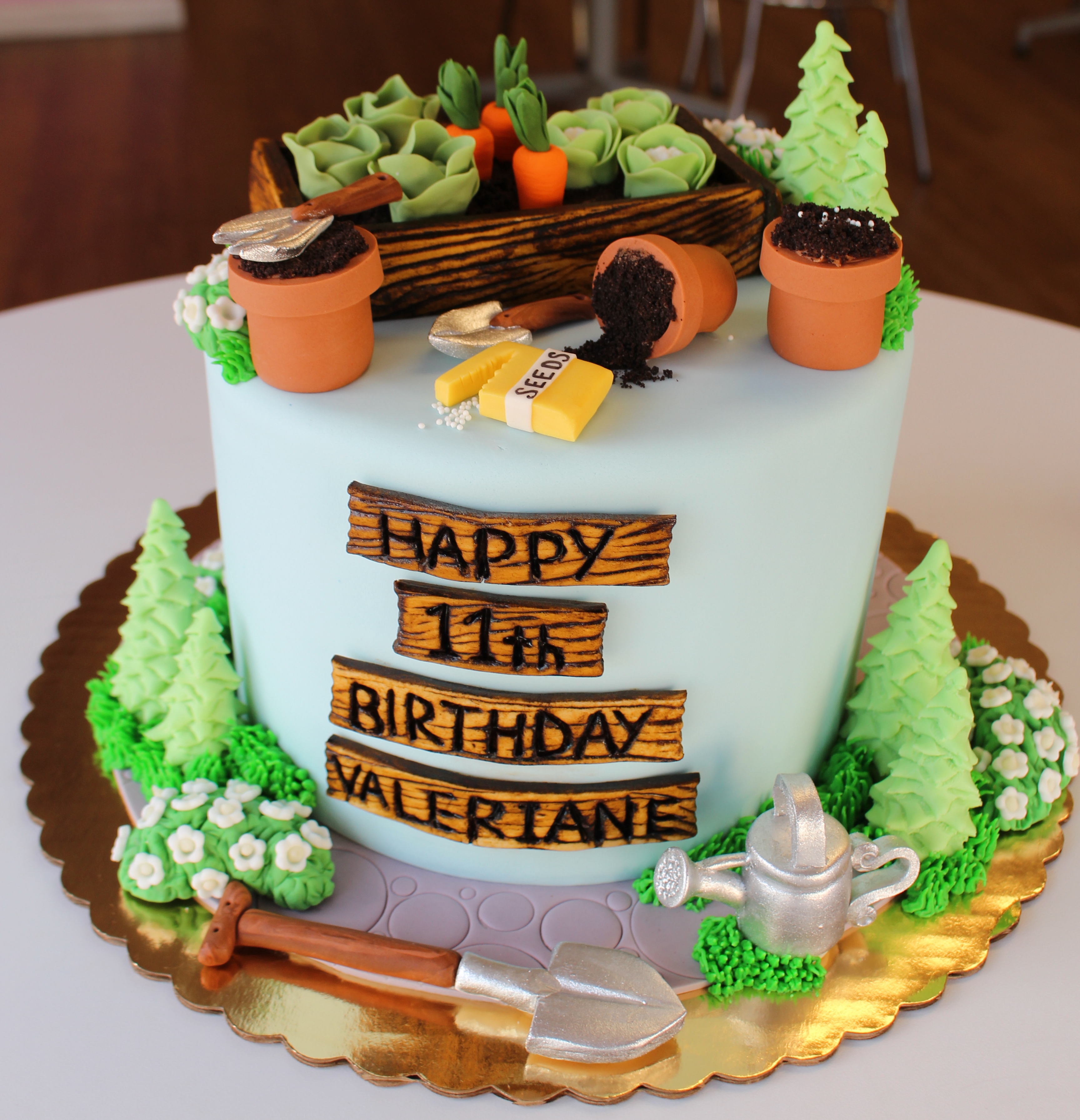 Light Blue Garden Theme Kids Birthday Cake with Fondant Flowers Plants Pots Tools and Watering Can