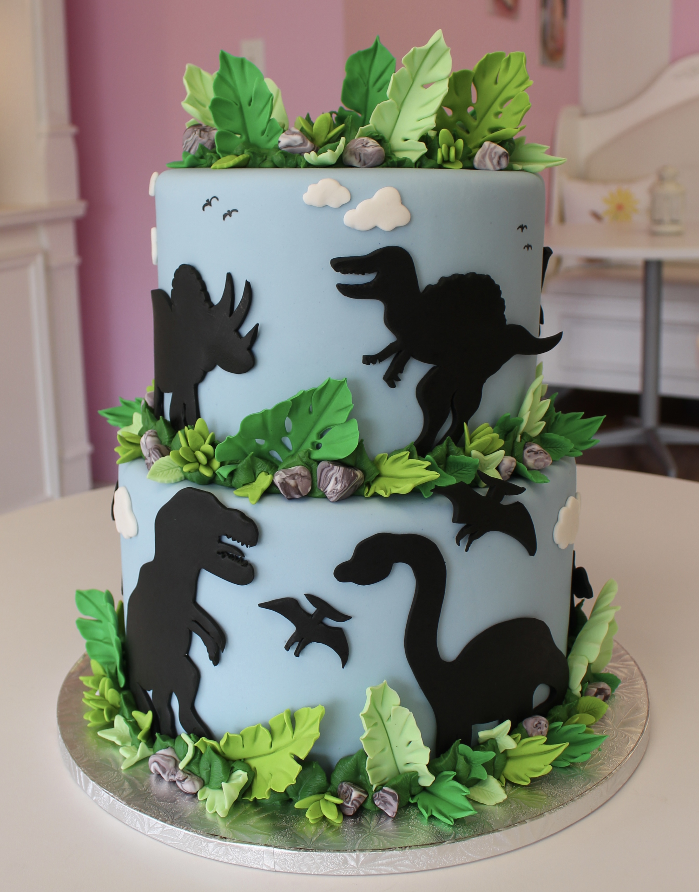 Light Blue Minimalist Dinosaur Birthday Cake with Fondant Dinosaurs and Jungle Foliage