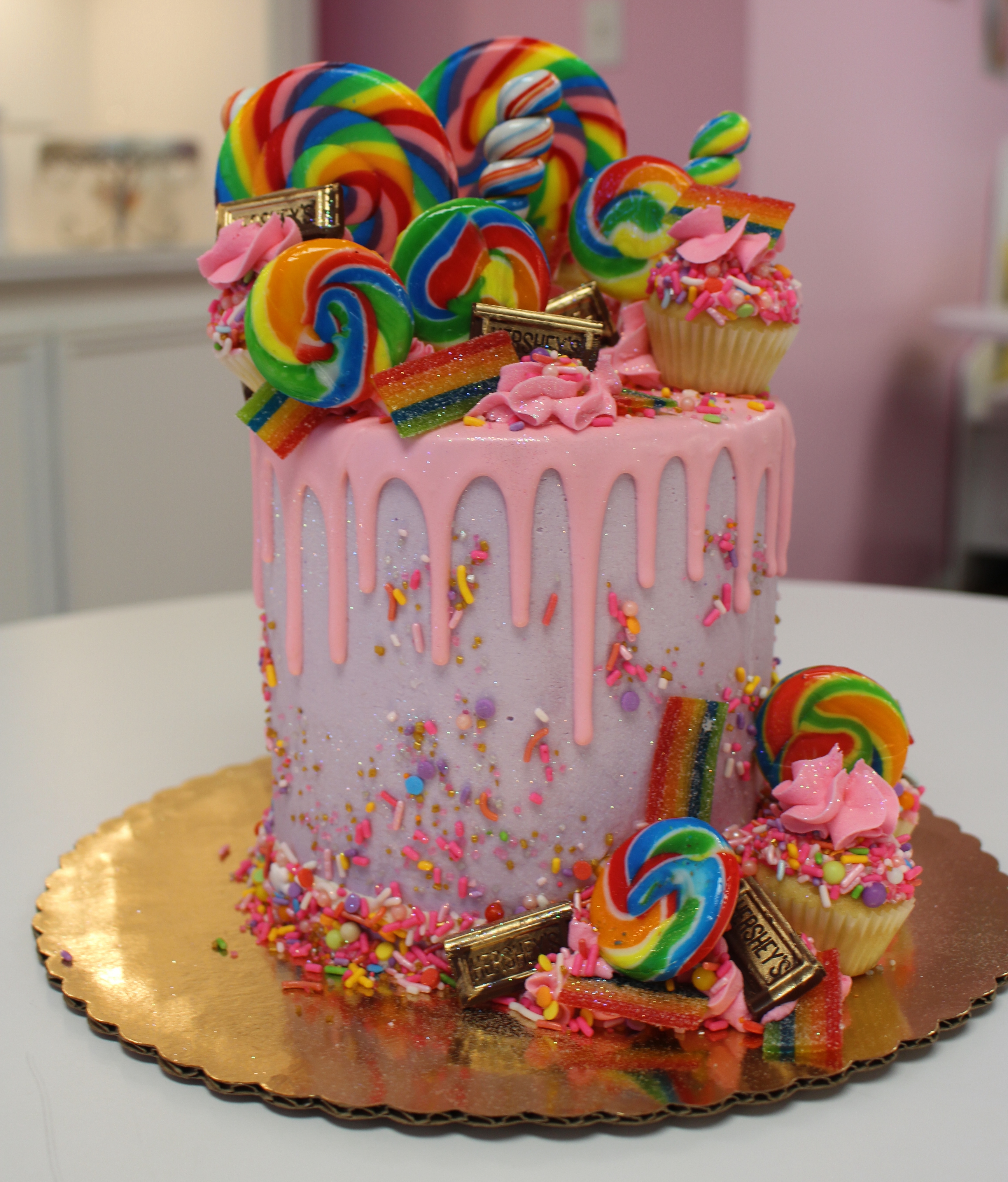 Purple with Pink Drip Candyland Theme Cake with Real Lollipops Mini Cupcakes and Candies