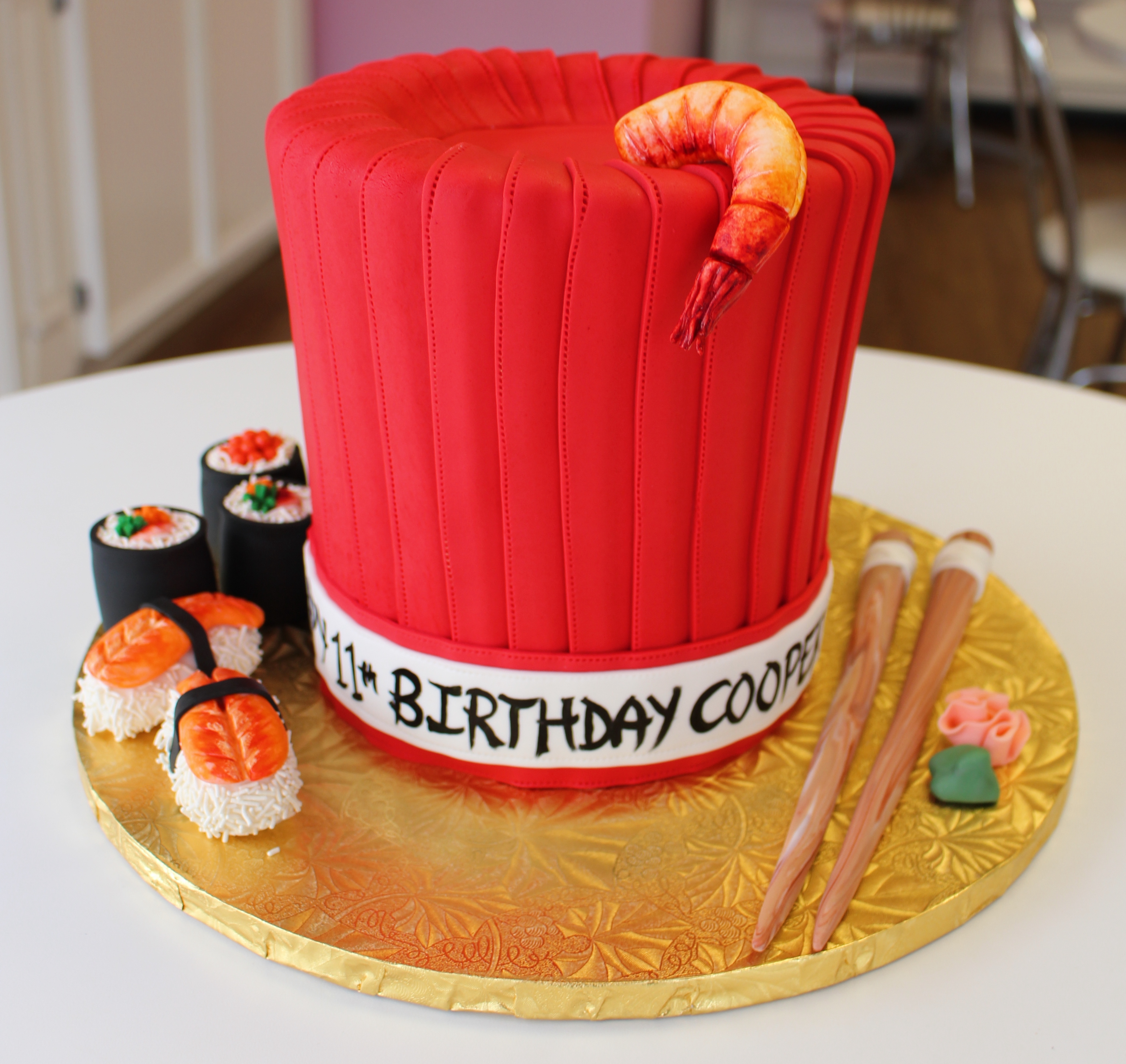 Red Hibachi Chef Hat Shaped Cake with Fondant Shrimp Sushi Rolls and Chop Sticks