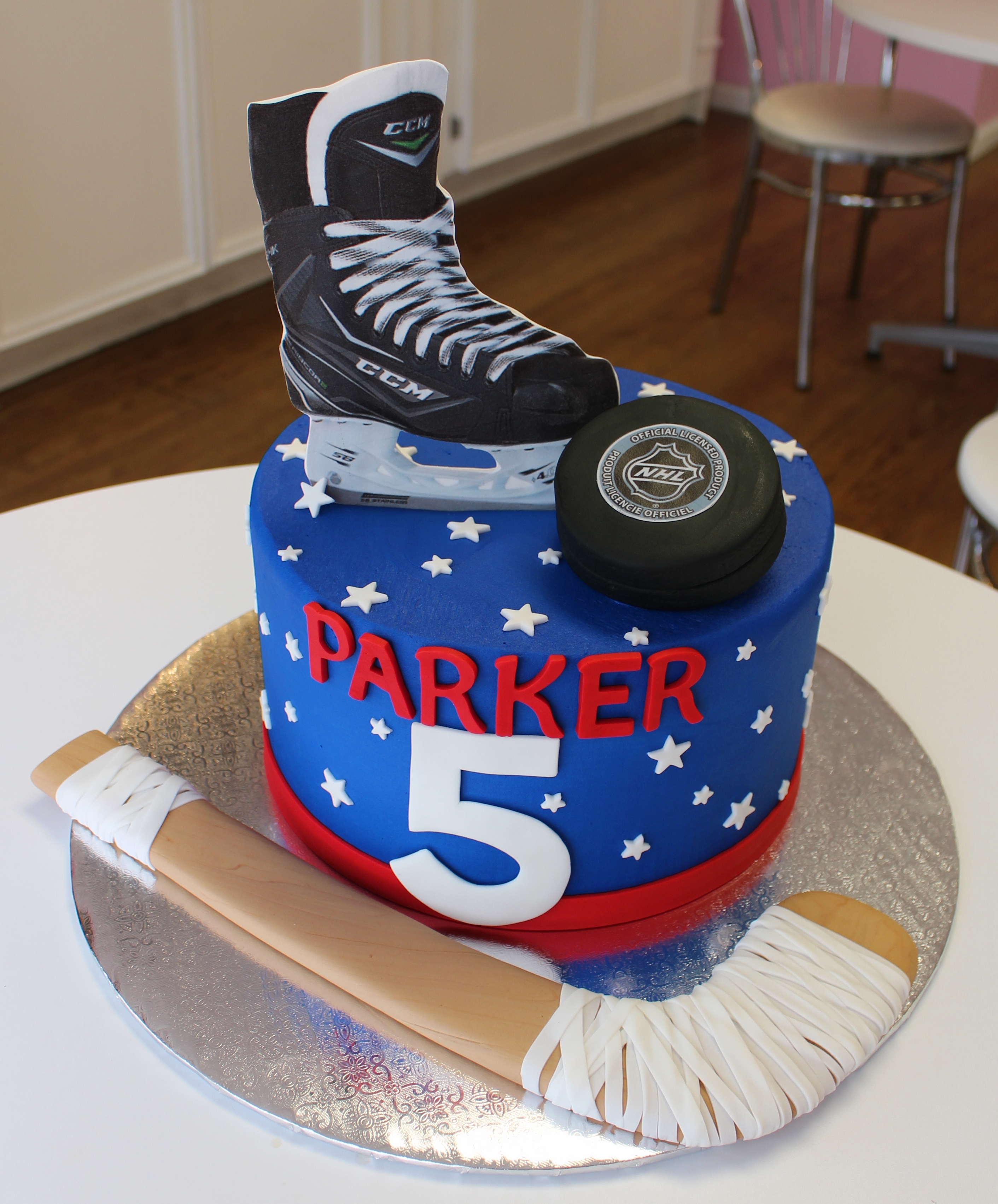 Red White and Blue Hockey Theme Kids Birthday Cake with Fondant Puck Hockey Stick and Skates