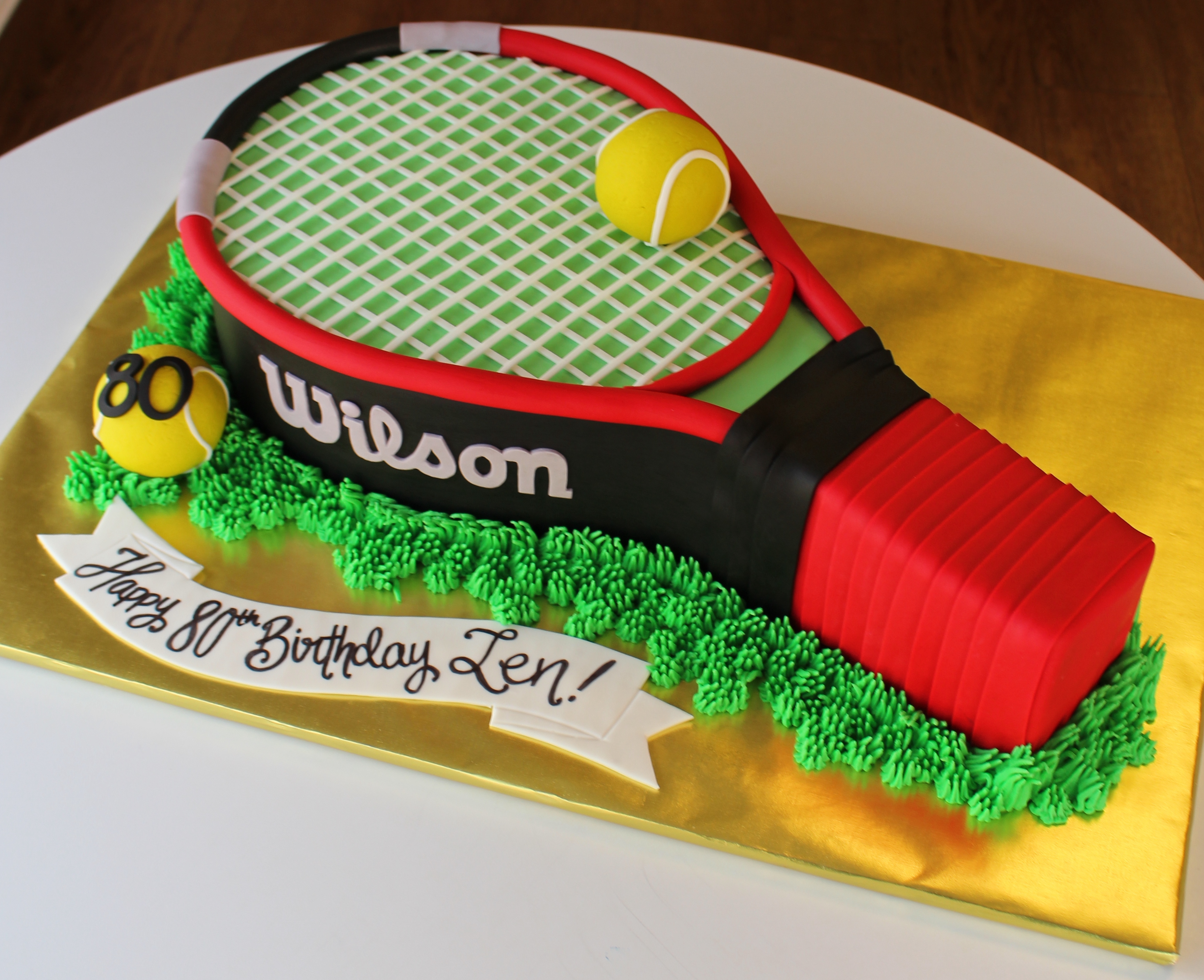 Tennis Racket Shaped Cake With Piped Buttercream Grass and Fondant Tennis Balls
