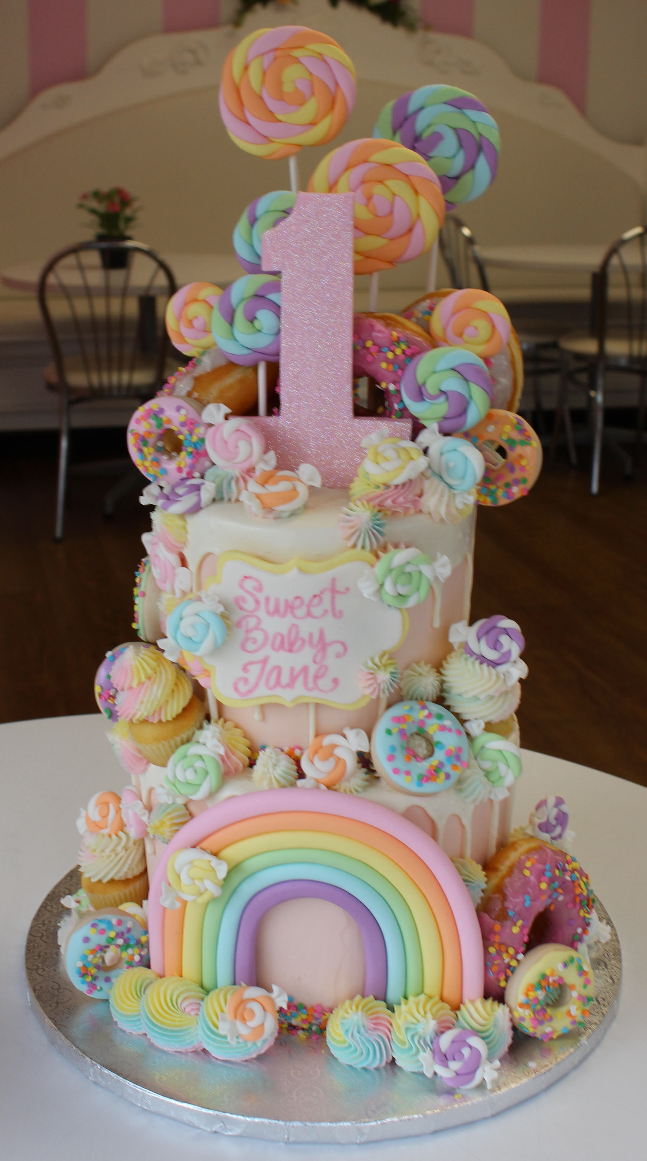 Two Tier Beige Candyland Theme Girls First Birthday Cake with Pastel Rainbow Sugarwork