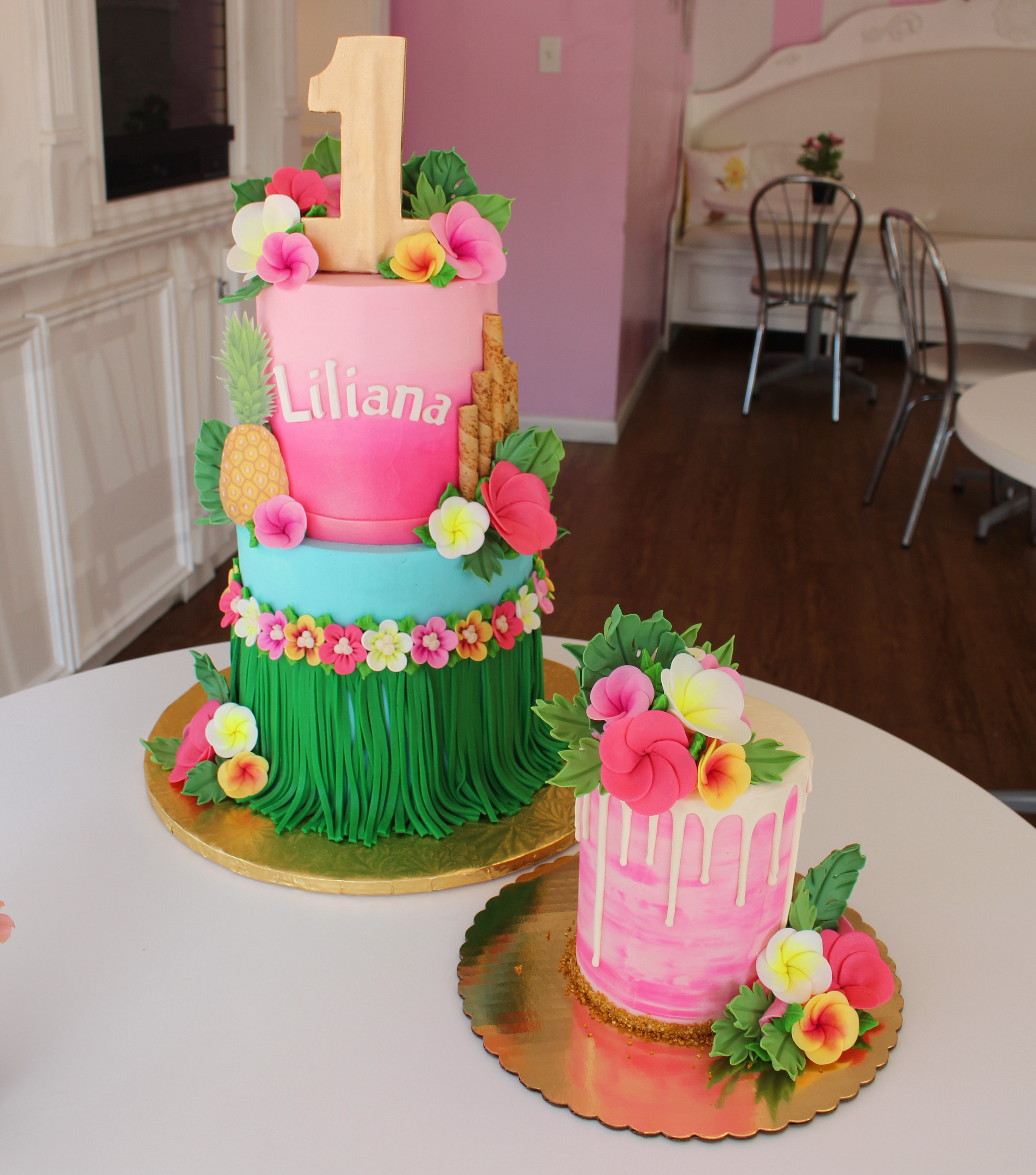 Two Tier Pink and Blue Hawaiian Luau Theme Girls First Birthday Cake with Fondant Flowers and Hula Skirt
