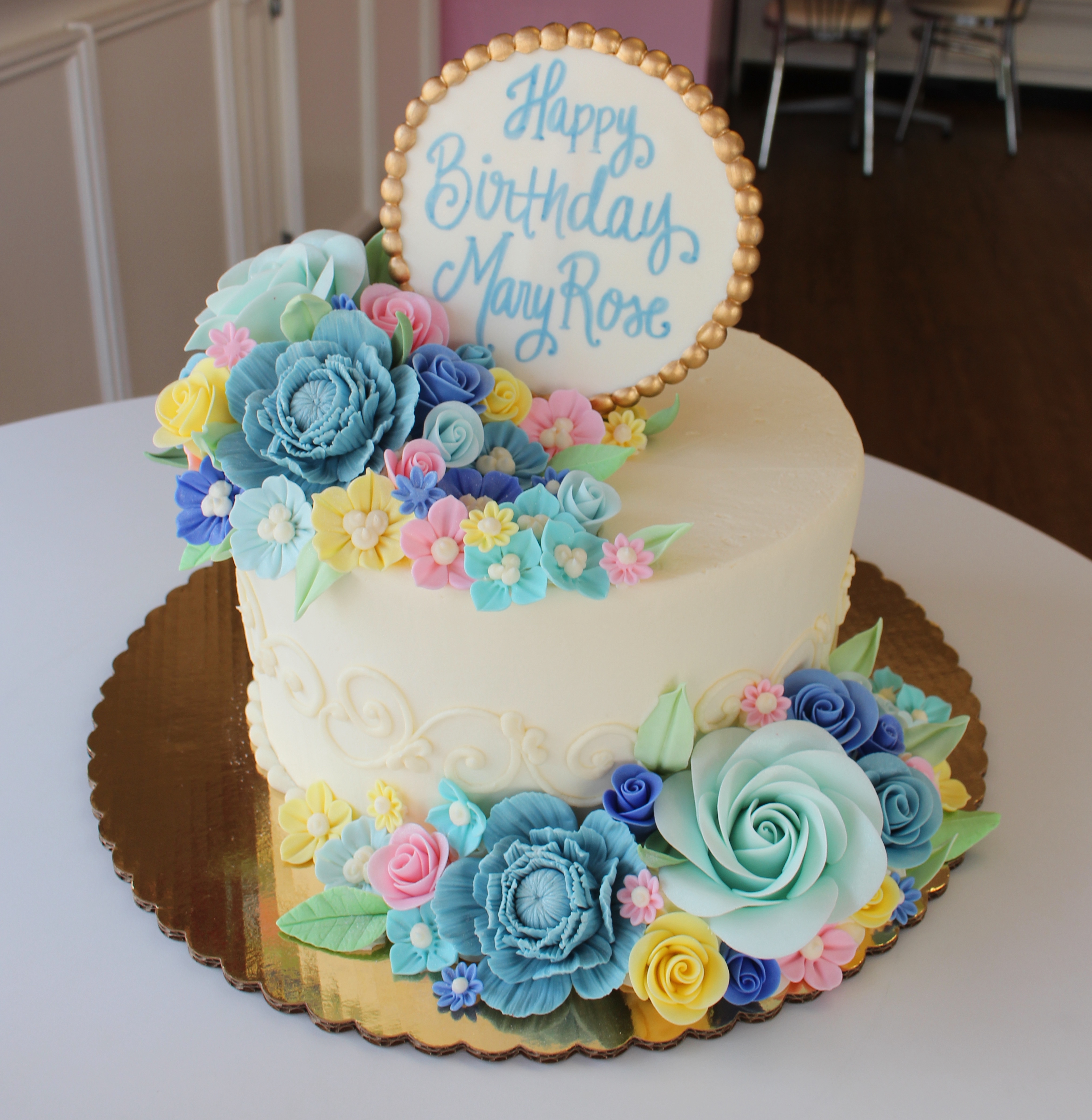 White Elegant Birthday Cake with Pastel Fondant Flowers and Leaves