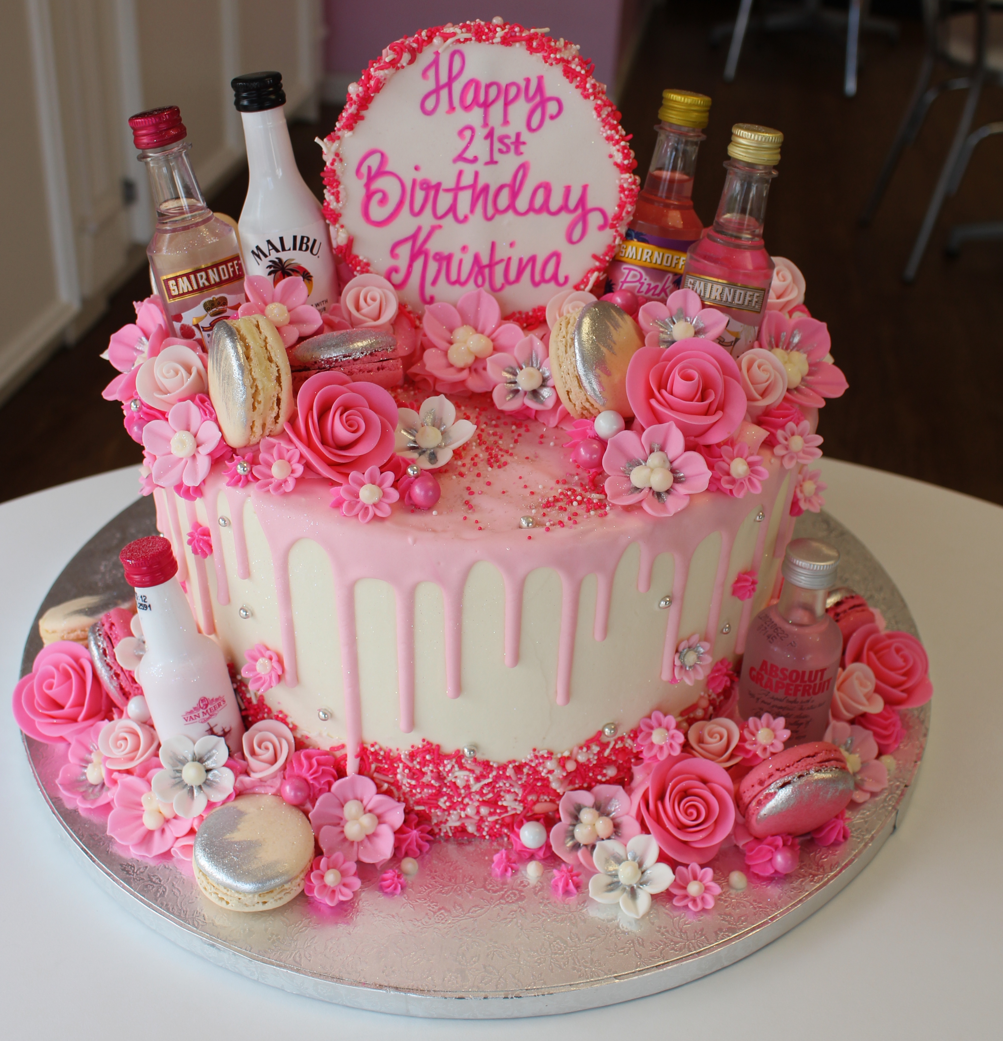 White and Pink Cake with Mini Bottles Flowers and Macarons